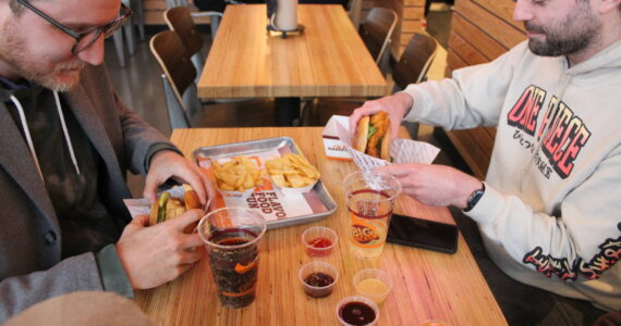 Photo by Bailey Jo Josie/Alb Media.
Nigel Quinn and Kyle Martin are about to take their first bites from the first order at Renton’s Big Chicken.